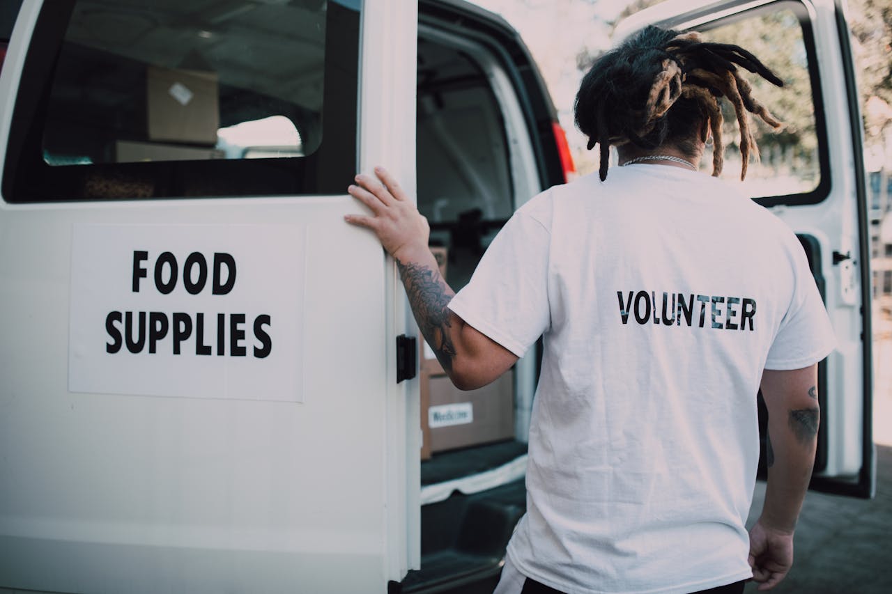 Mastering the First Impression: Your intriguing post title goes here A volunteer loads food supplies into a van, showcasing charity and community support.